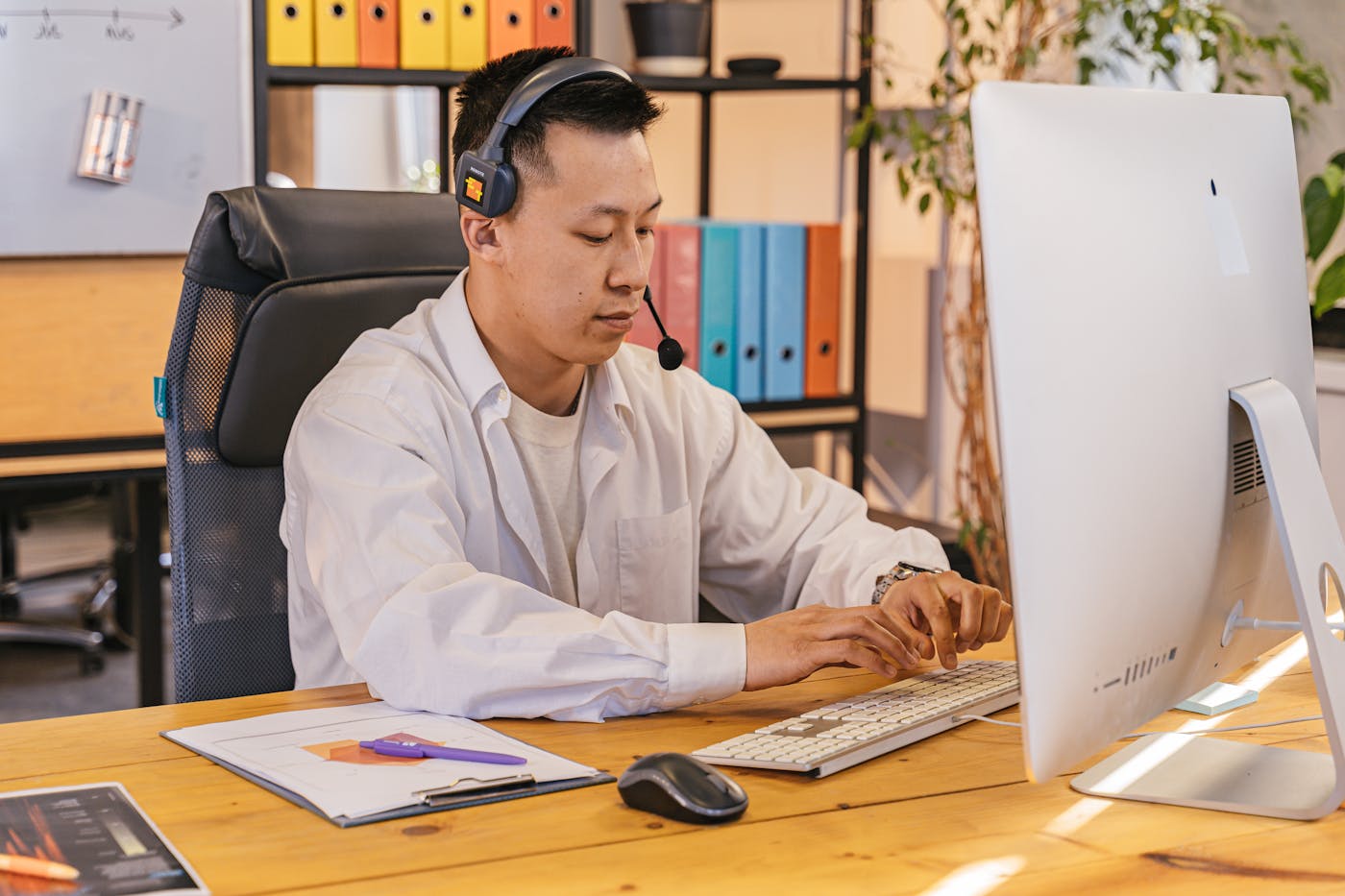 A senior engineer at a desk with a headset, ready to answer