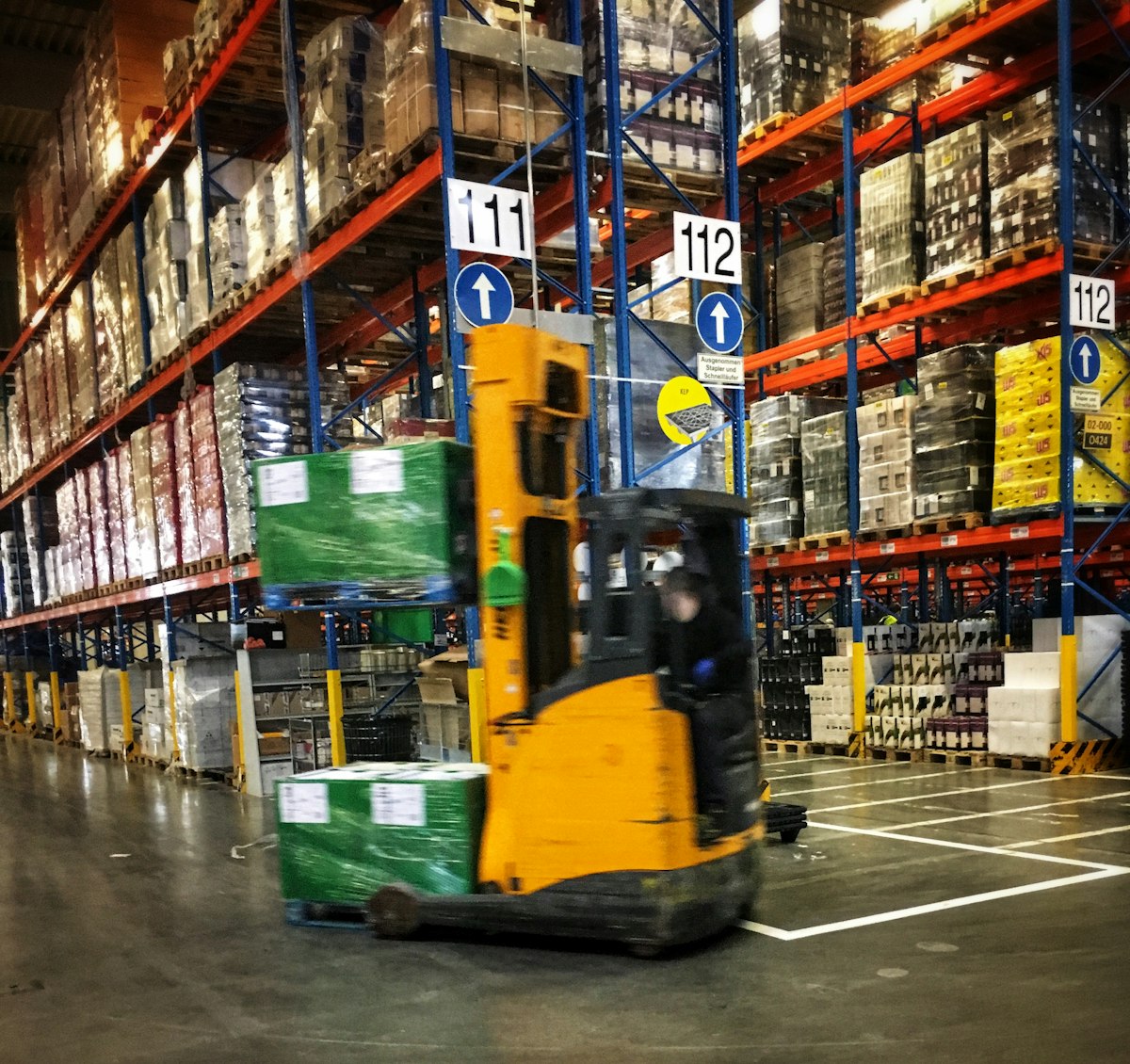 Forklift moving pallets through a logistics warehouse