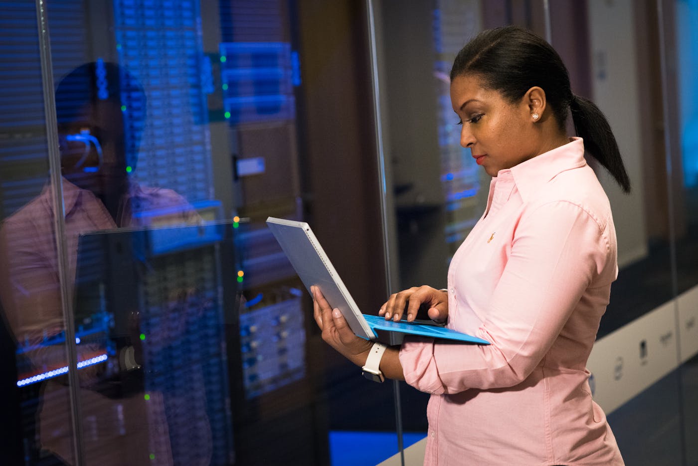 Phoenix engineer actively working on a laptop beside a lit server rack