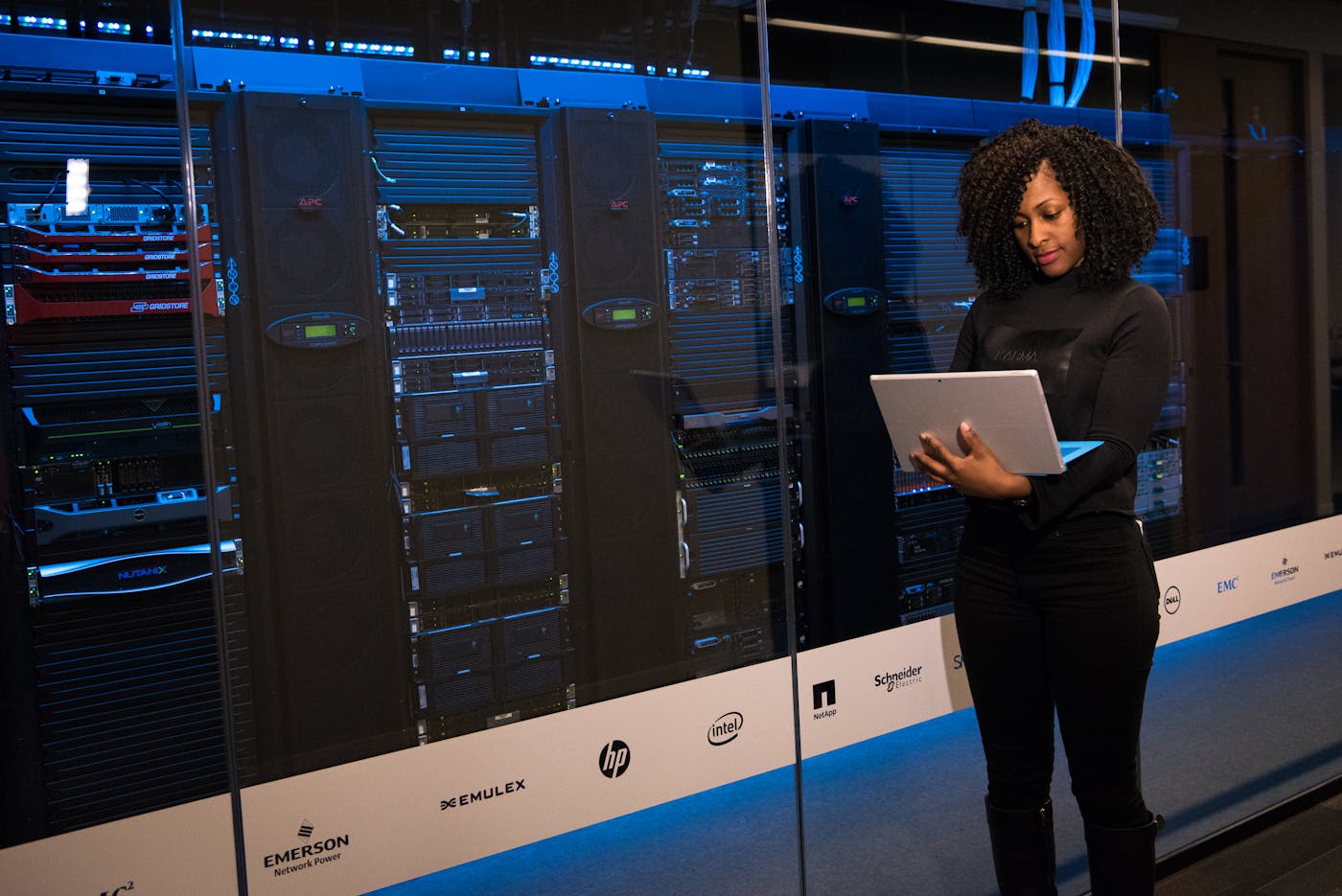 Phoenix engineer working on a laptop inside a blue-lit server aisle