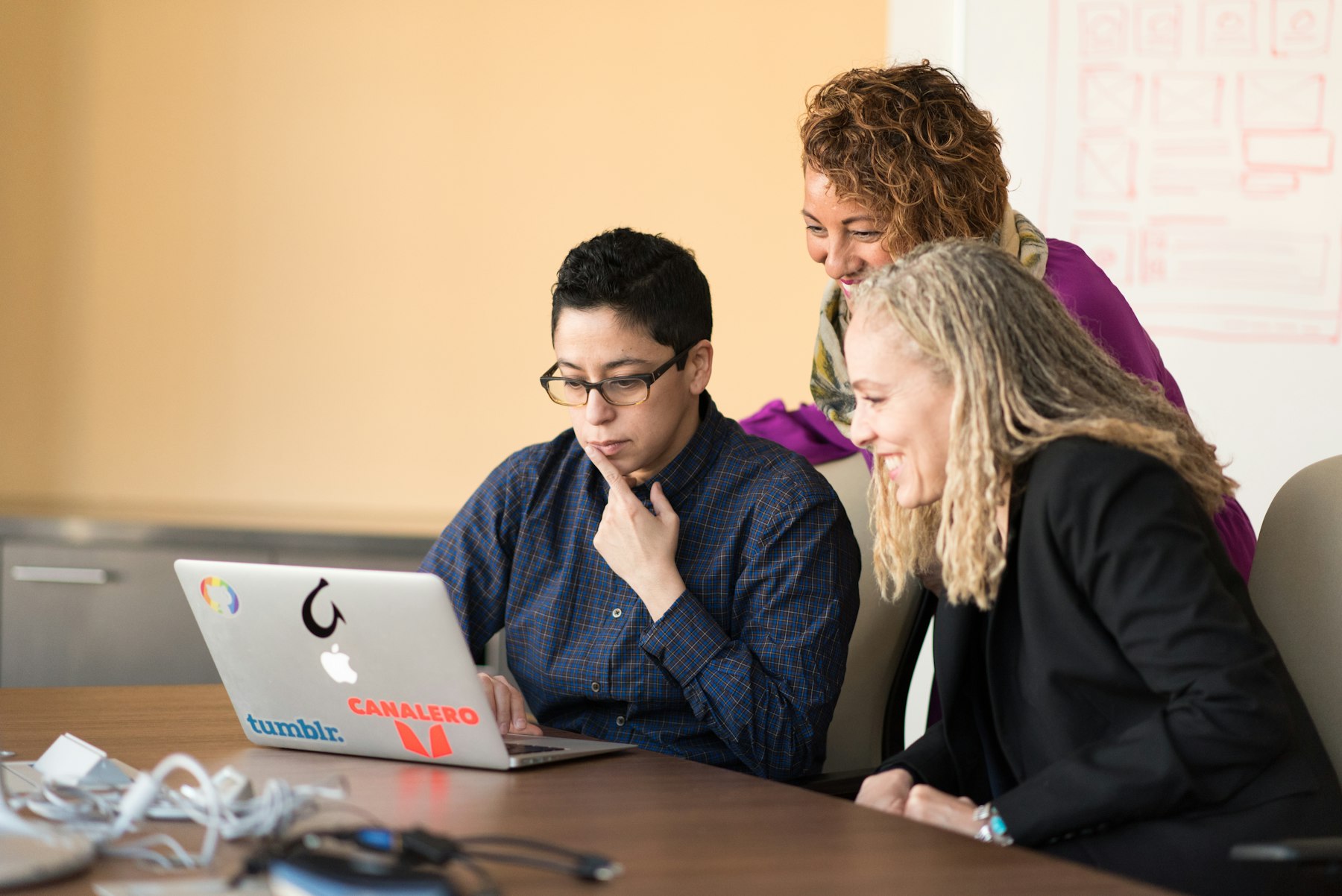 Phoenix team collaborating around a laptop in a shared working session